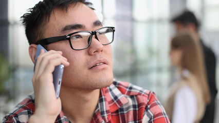 Businessman talking on smartphone and working in office.