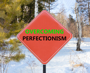 Overcoming perfectionism symbol. Concept words Overcoming perfectionism on beautiful red road sign. Beautiful forest trees snow background. Business Overcoming perfectionism concept. Copy space.