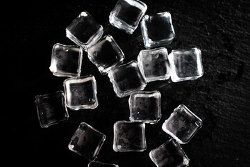 Ice cubes on a black background. transparent ice on a stone