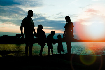 happy family by the sea on nature silhouette background