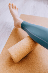 Close up of woman doing lower leg MFR massage on a cork roller