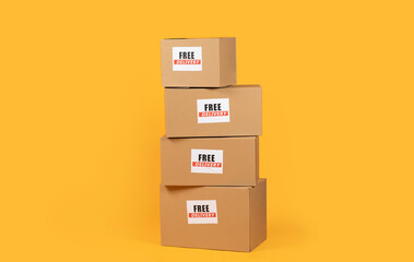Four identical boxes with free delivery text are arranged vertically on a vibrant yellow background. The boxes are stacked neatly on top of each other