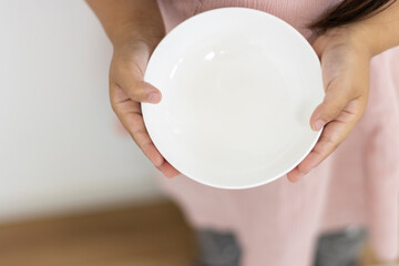 空っぽの皿を持つ女の子（顔無し、3歳、日本人）