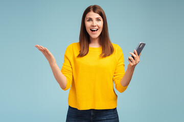 Excited, happy, smiling middle aged woman holding mobile phone, using mobile application