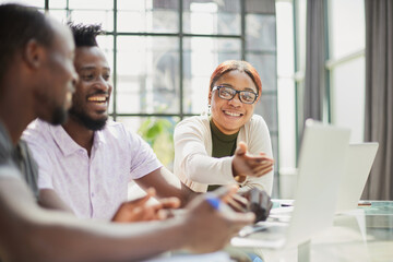 Fototapeta premium Group of business people in casual wear sitting together at the table and looking at the laptop
