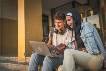 teenage couple students watch video movie on laptop computer at school