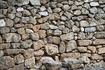 fragment of a stone wall of an ancient building in the city of Paphos