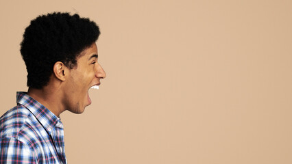 Profile portrait of screaming teen guy, white background, copy space