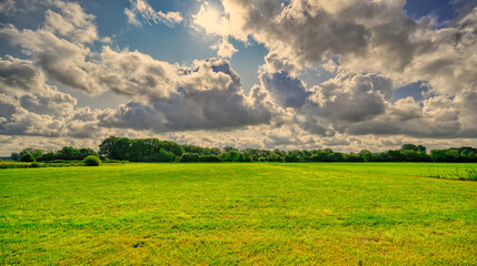 Big cloud formations passing over a pastoral landscape in The Netherlands.