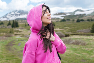 Relaxed woman breathing fresh air in a green spring  mountain