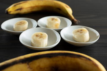 A view of small saucers each with a banana slice.