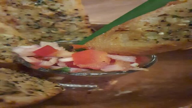 Different colorful meals for breakfast or lunch time on a plate with cutlery on woman's hands. Fried eggs, omelette, bruschetta and sausage on a wooden teble in restaurant. Flat lay top view.