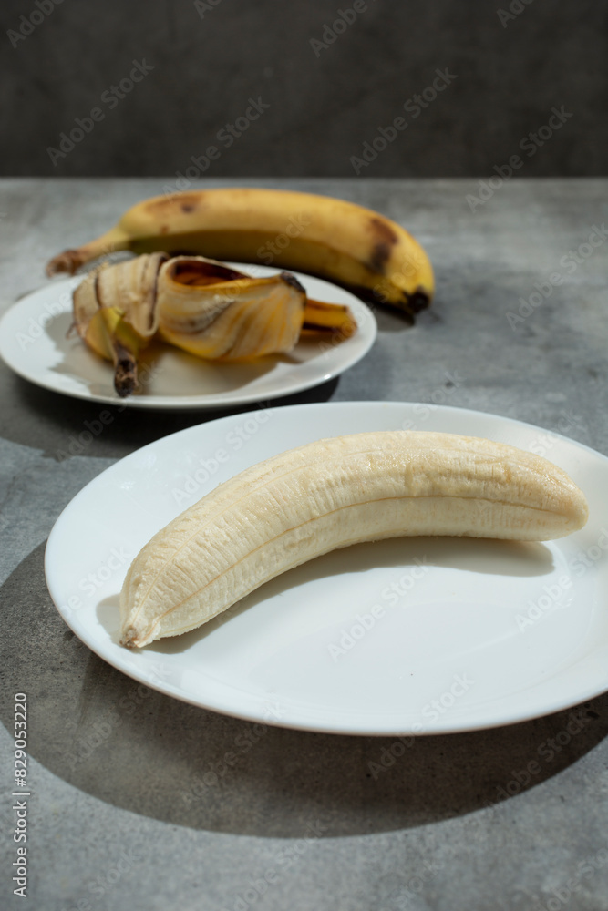 Sticker A view of a peeled banana on a plate, as still life.