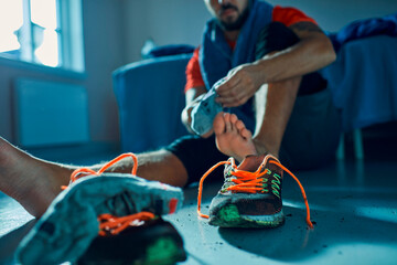 Man taking off dirty shoes at home after workout