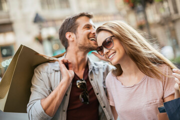 Happy couple shopping together in the city
