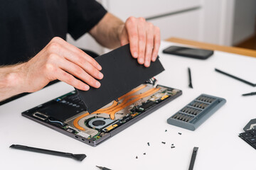 Man repair his broken laptop computer at home