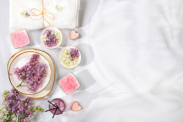 Spa and wellness composition with aromatic pink salt, lilac water and lilac flowers, aromatherapy...