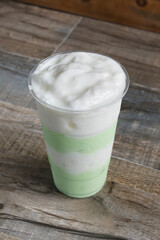 A view of a white and green striped milk tea beverage.