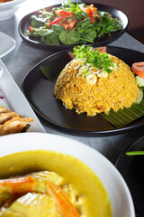 A view of a plate of curried fried rice, among other Asian entrees.