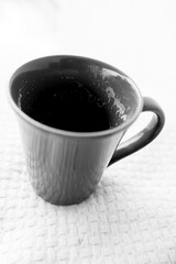 black and white photograph of a hand holding a cup of coffee