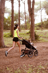 Beautiful young woman runs with a stroller.