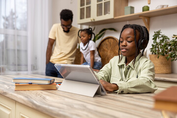 Obraz premium Multicultural little girl using digital software on tablet for online education