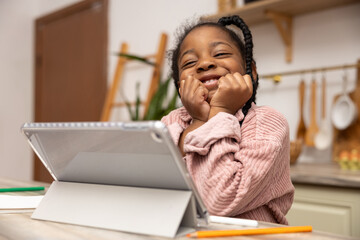 Little girl browsing internet on her tablet exploring educational websites for her school project