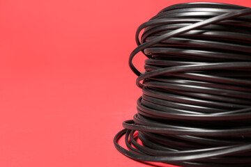 Rolled cables on red background, closeup