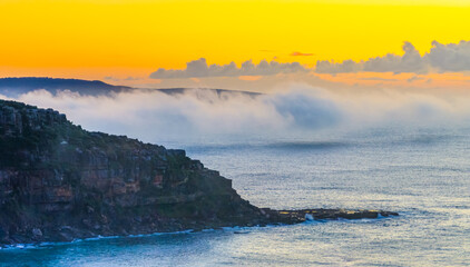 Sunrise over the sea with a low cloud bank and fog