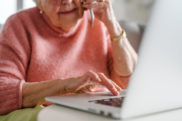 Online and phone scams targeting seniors. Scammer sending email to elderly woman, asking for money,...