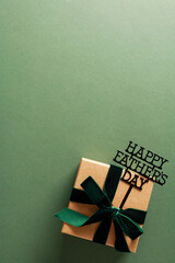 Happy Fathers Day concept. Top view gift box with topper Happy Fathers Day on vertical green background.