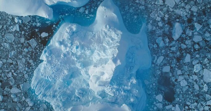 Frozen polar ocean background aerial view. Massive iceberg floating peacefully in Antarctica waters. Melting ice floes surface zoom out panorama. Inspiring natural beauty and tranquility landscape
