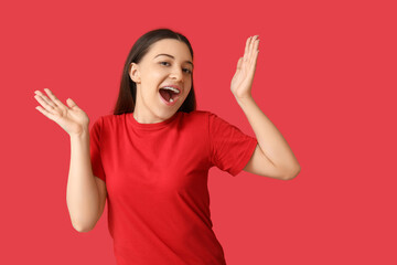 Happy young woman in stylish red t-shirt on color background