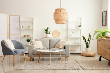 Interior of modern living room with grey sofa, coffee table and armchair