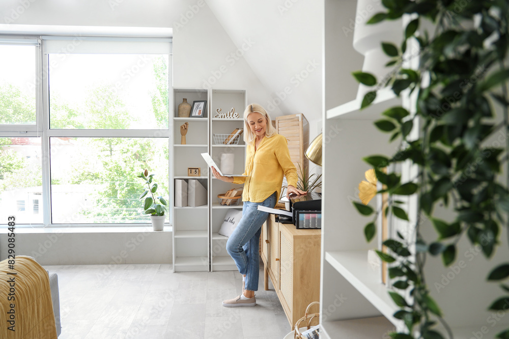 Canvas Prints mature woman using laptop and printer at home