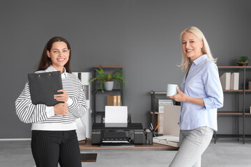 Female colleagues near printer in office