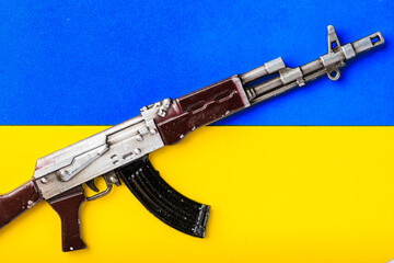 Toy gun is on the flag of Ukraine. Symbolic abstract background or backdrop about war