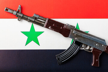 A toy gun is placed on Syria flag