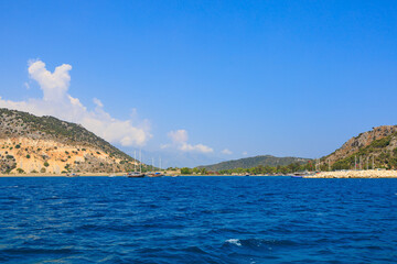 Naklejka premium View of the rocky shore from the sea. Mediterranean Sea in Turkey. Popular tourist places. Background