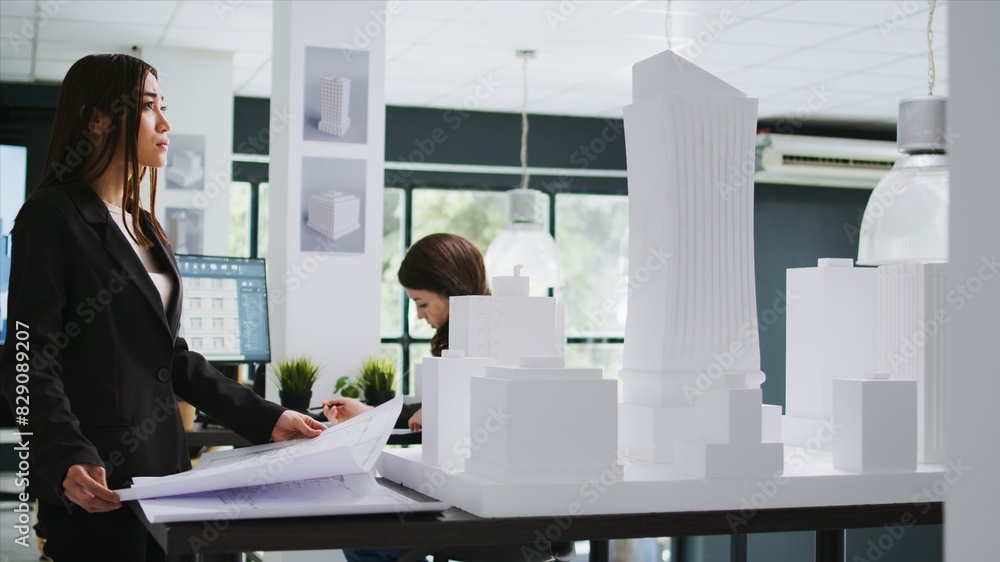 Poster architecture office employee looking at building model, working with printed project blueprints. arc