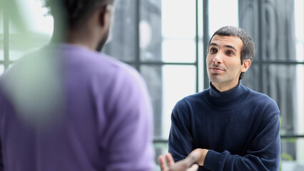 Diverse friendly male colleagues talking while walking