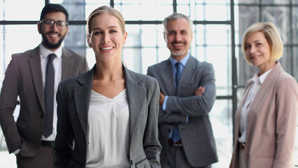 business woman with crossed arms against the background of a business team