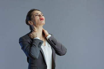 tired elegant woman employee having neckpain isolated on grey