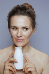 pensive modern woman with cosmetic cream jar