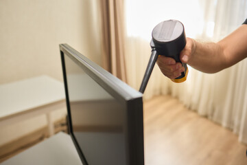 Someone is using a spray bottle to clean a television screen