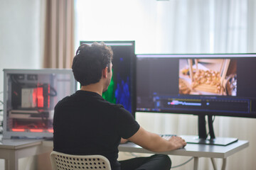 Focused creative man working editing video footage in creative office studio.