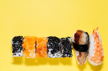 delicious variety of sushi on yellow background