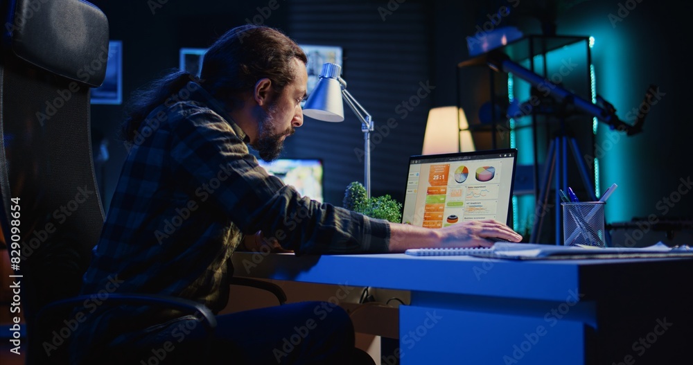 Poster man concerned about statistical data financial graphs on laptop screen while researching data for co