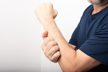 Middle-aged man scratching his forearm. Skin disease.