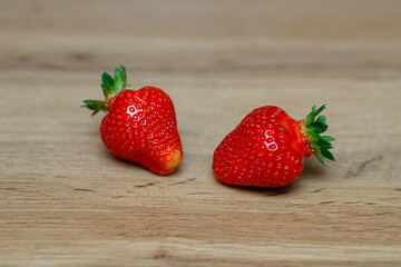 Fresh delicious selected strawberries on a brown wooden table